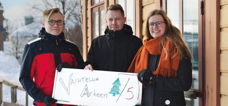 Kuvassa kolme henkilöä. Vasemmalta oikealle: Kai Ikonen, Mika Korhonen ja Riikka Rainio. Heillä on kyltti kädessä, jossa lukee: vaihtelua arkeen 6/5