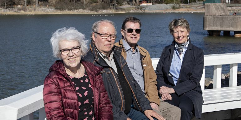 Kuvassa neljä henkilö istuu veden äärellä. Rymättylän omakotiyhdistyksen sihteeri Liisa Valmunen ja puheenjohtaja Pirkka Turkki, Merimaskun omakotiyhdistyksen puheenjohtaja Seppo Ansamaa ja Naantalin omakotiyhdistyksen hallituksen jäsen Merja Leino.